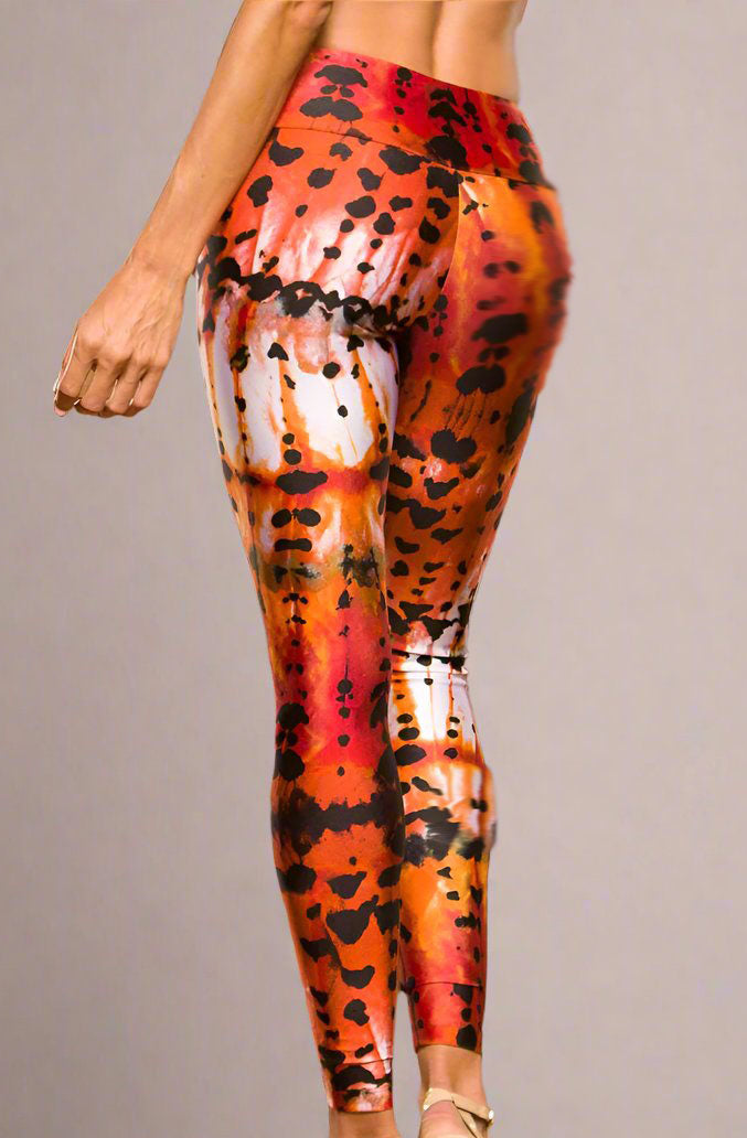 A model wearing a pair of Alto Giro Art Leopard Leggings with a wide waist, showcasing a vibrant animal print design.