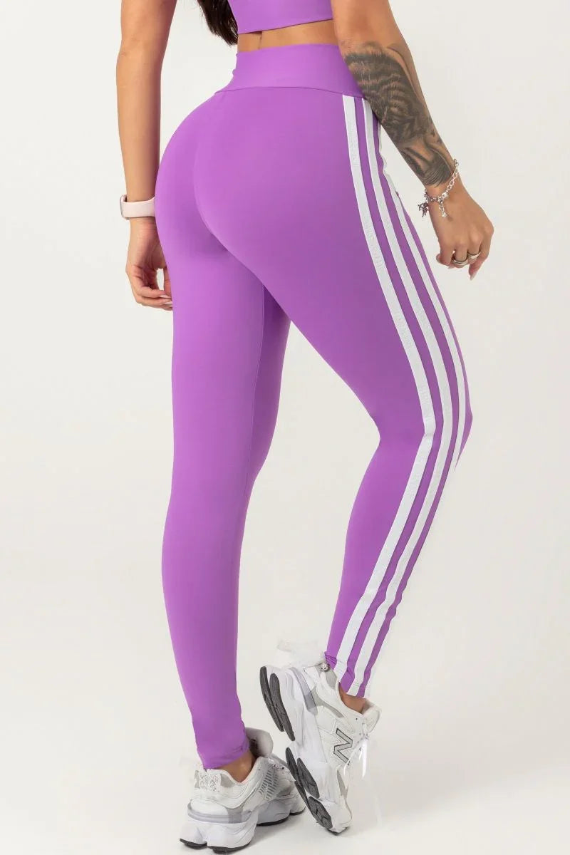 back view of A model wearing a purple Hipkini Victory V Front Legging with white side striping and high-waisted.