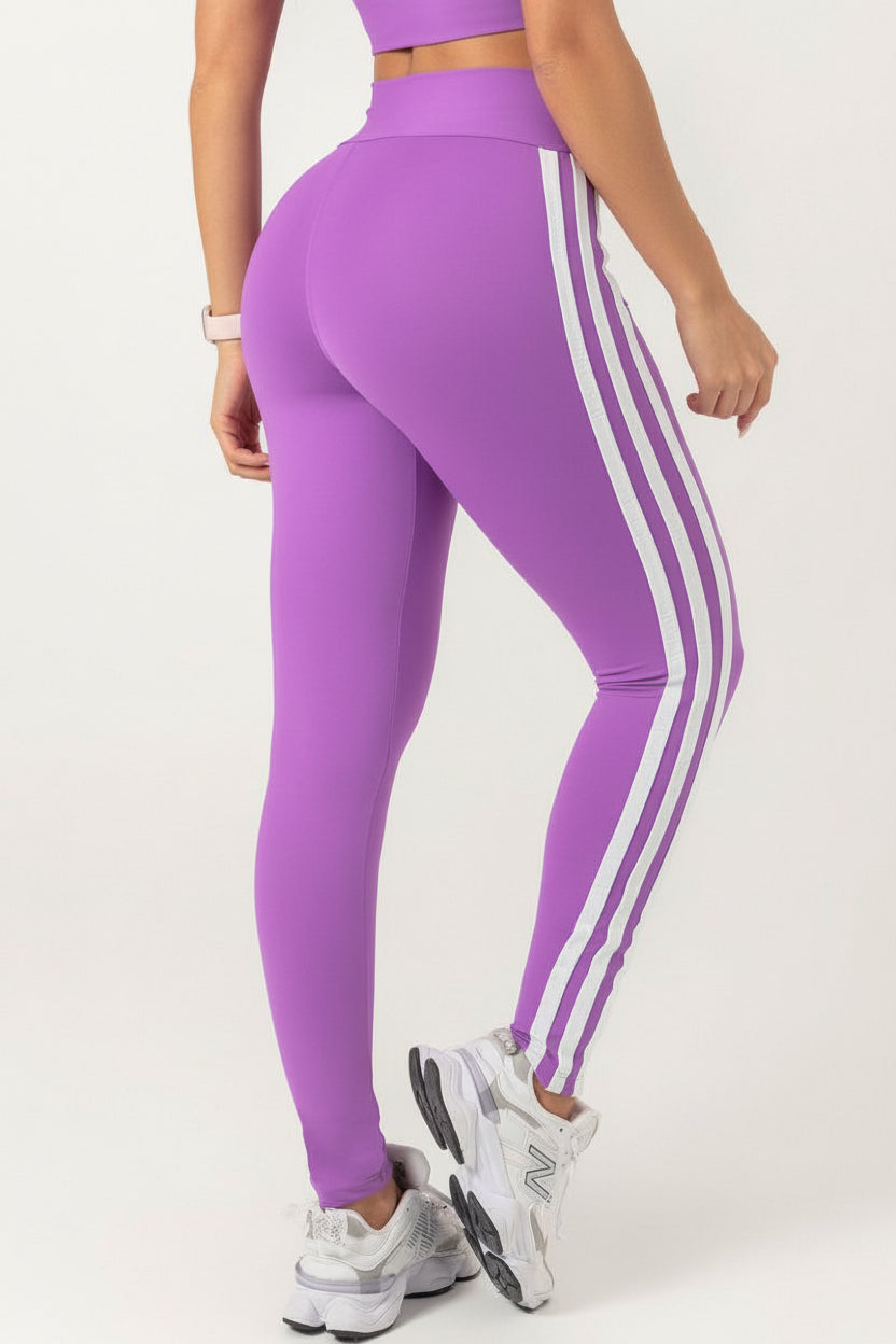 back view of A model wearing a purple Hipkini Victory V Front Legging with white side striping and high-waisted.