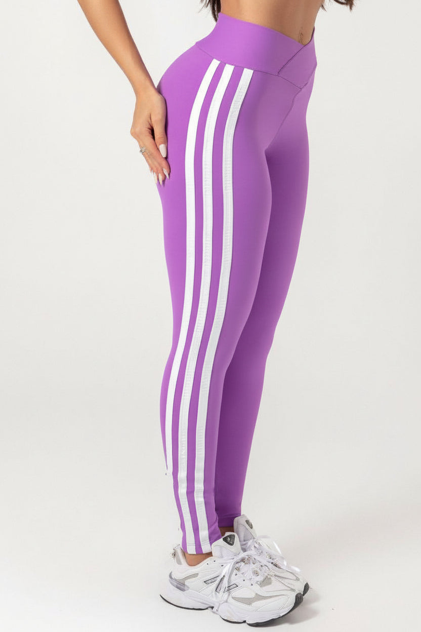 A person wearing a purple Hipkini Victory V Front Legging with white side striping, paired with a white top and white sneakers.