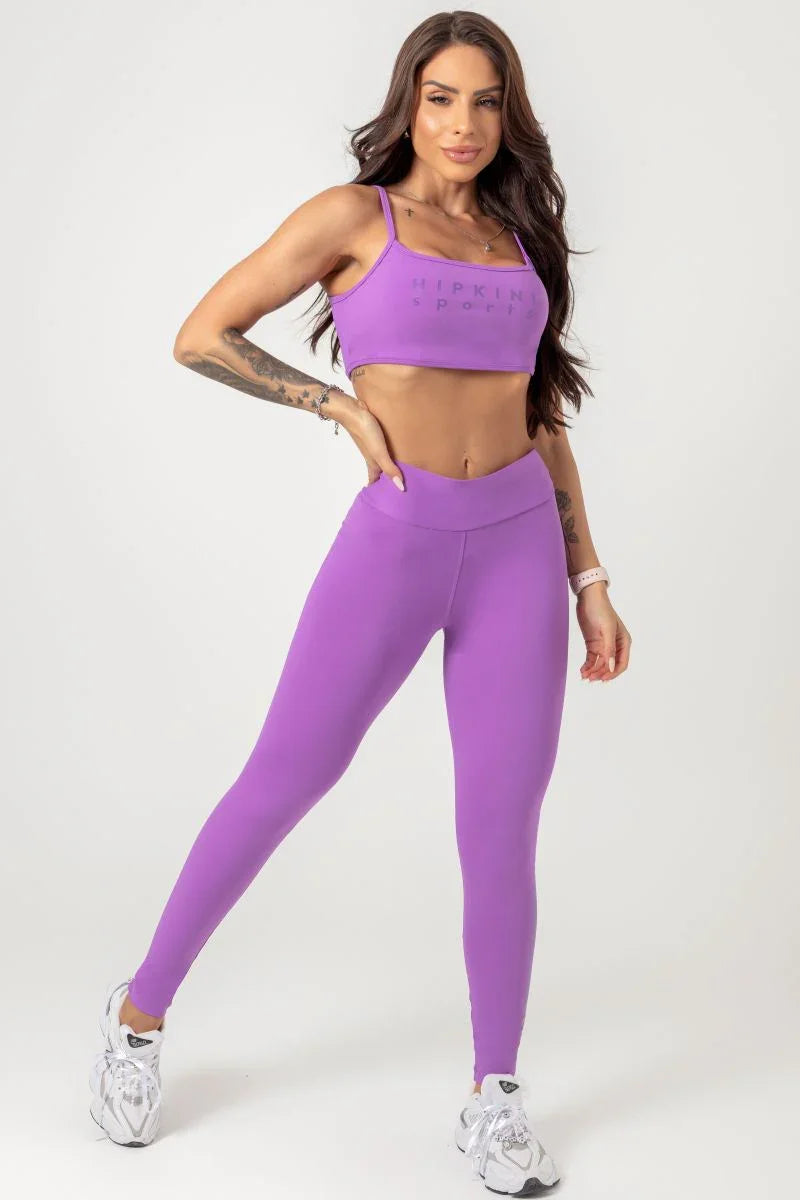 Woman wearing a violet purple athletic outfit on a white background